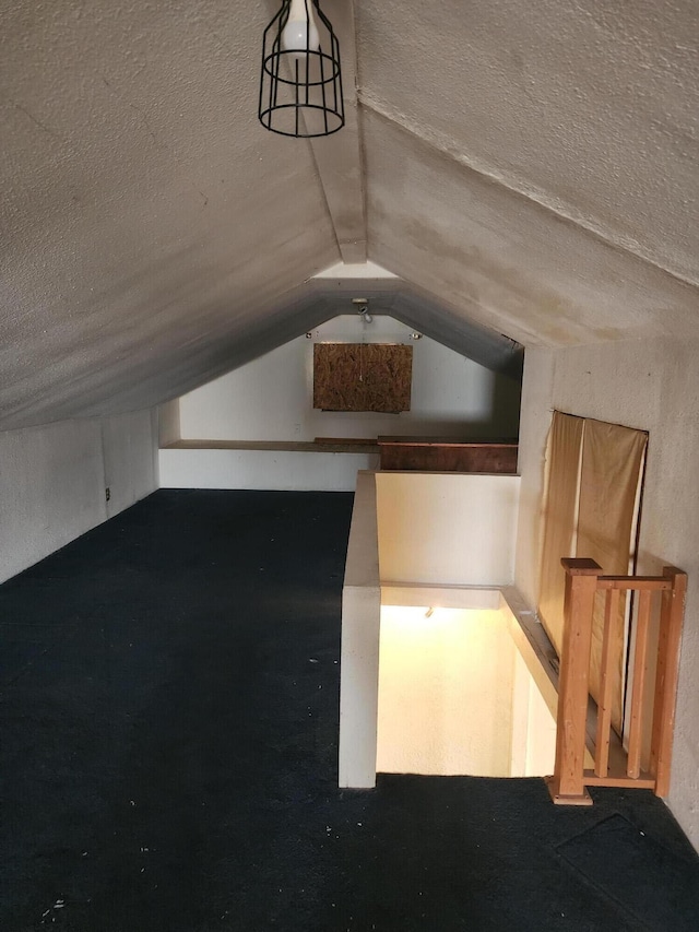 additional living space with vaulted ceiling and a textured ceiling