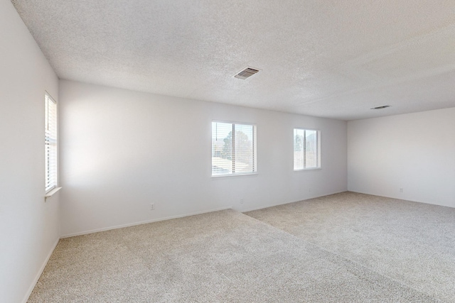 carpeted spare room featuring a textured ceiling