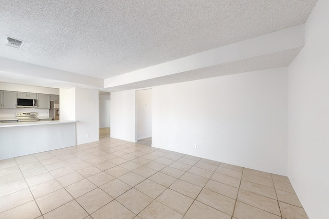 unfurnished room with a textured ceiling and light tile patterned flooring