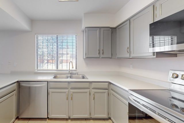 kitchen featuring light tile patterned flooring, appliances with stainless steel finishes, sink, and gray cabinetry