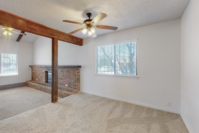 unfurnished living room with ceiling fan, a brick fireplace, carpet floors, and a textured ceiling