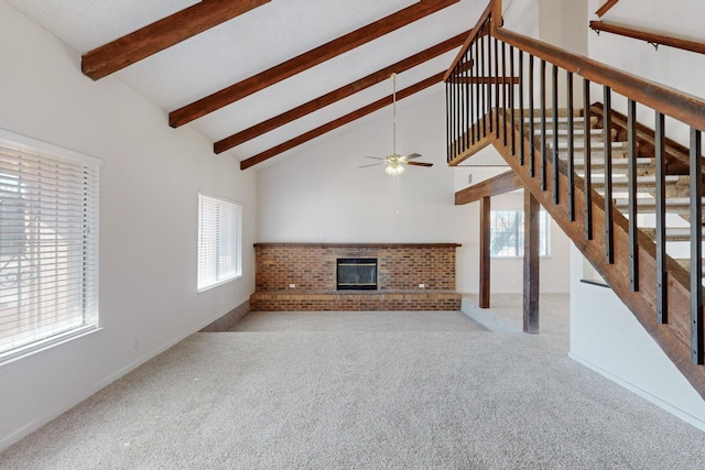 unfurnished living room with beamed ceiling, a healthy amount of sunlight, high vaulted ceiling, and a brick fireplace