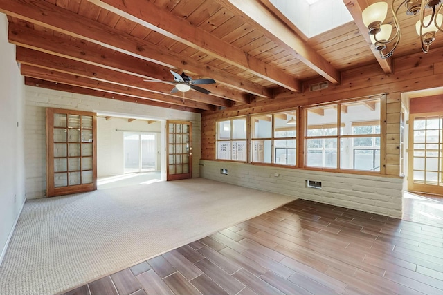 unfurnished room featuring wood-type flooring, a skylight, wooden ceiling, beamed ceiling, and ceiling fan