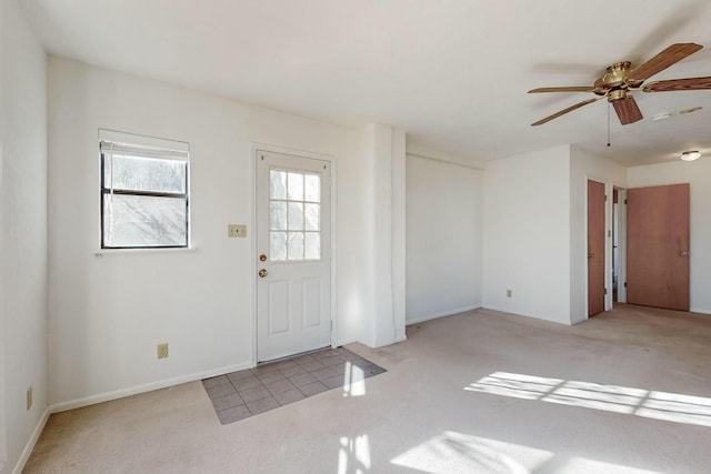 carpeted foyer entrance with ceiling fan