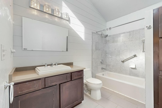 full bathroom with tile patterned flooring, vanity, tiled shower / bath, vaulted ceiling, and toilet