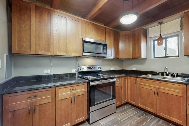 kitchen with beamed ceiling, sink, dark stone countertops, hanging light fixtures, and stainless steel appliances