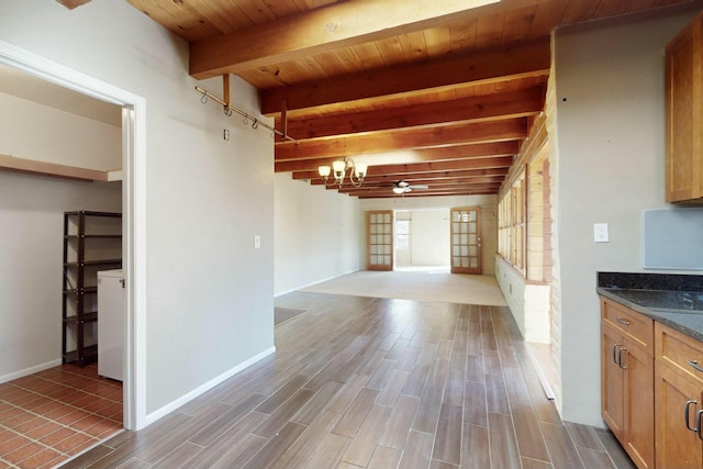 interior space with pendant lighting, a chandelier, dark stone countertops, wooden ceiling, and beamed ceiling