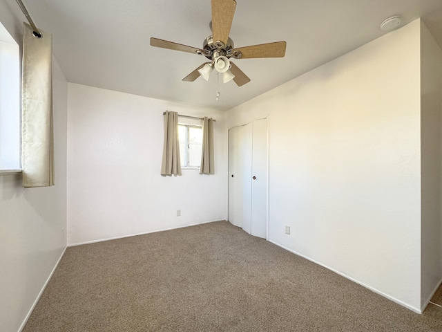 empty room featuring ceiling fan and carpet floors