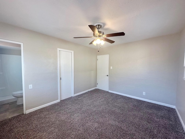 unfurnished bedroom with ceiling fan, connected bathroom, baseboards, and carpet flooring