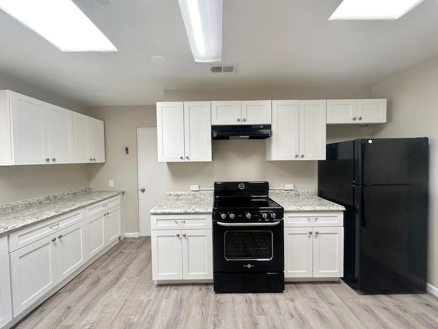 kitchen featuring white cabinets, under cabinet range hood, and black appliances