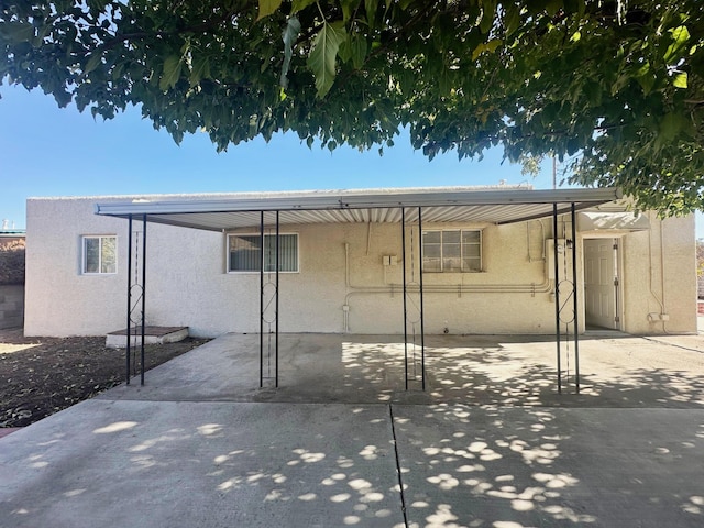 back of property featuring stucco siding