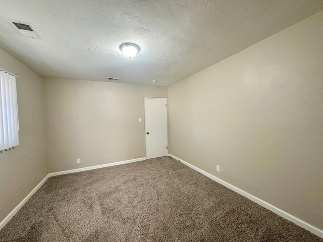 spare room with baseboards, visible vents, and carpet flooring