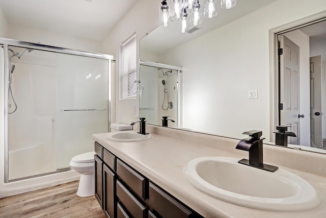 full bathroom featuring a shower stall, visible vents, a sink, and wood finished floors