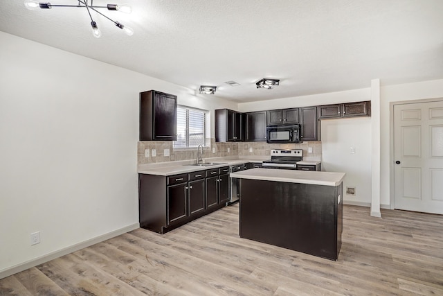 kitchen featuring black microwave, electric stove, a kitchen island, and light countertops