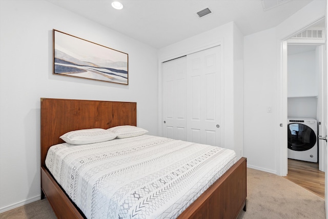 carpeted bedroom with washer / clothes dryer and a closet