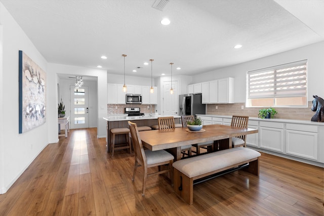 dining area with wood-type flooring, sink, and a textured ceiling