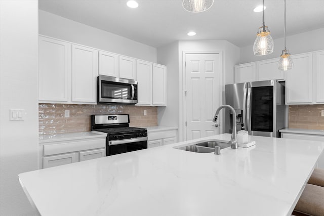 kitchen with appliances with stainless steel finishes, a kitchen island with sink, and sink