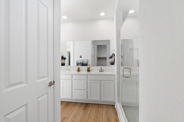 bathroom featuring vanity, hardwood / wood-style flooring, and a shower with shower door