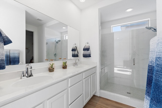 bathroom featuring an enclosed shower, vanity, and hardwood / wood-style flooring