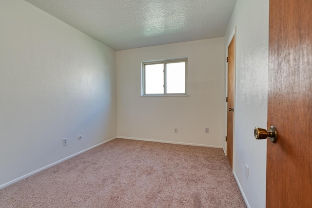 carpeted spare room featuring a textured ceiling