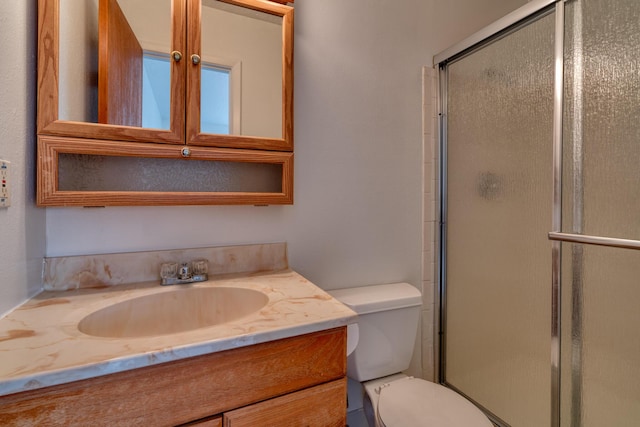 bathroom featuring vanity, toilet, and an enclosed shower