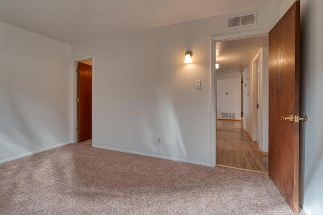 carpeted spare room featuring a textured ceiling