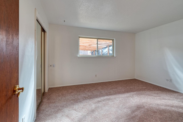 spare room featuring carpet flooring and a textured ceiling