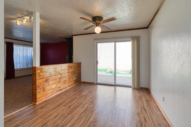 spare room featuring crown molding, ceiling fan, hardwood / wood-style flooring, and a textured ceiling