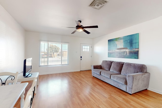 living room with ceiling fan and light hardwood / wood-style flooring