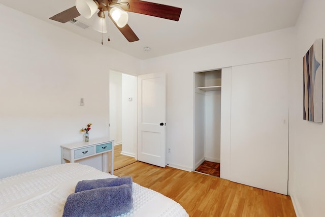 bedroom with wood-type flooring, a closet, and ceiling fan