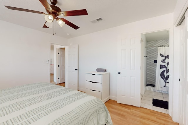 bedroom with ensuite bath, light hardwood / wood-style flooring, and ceiling fan