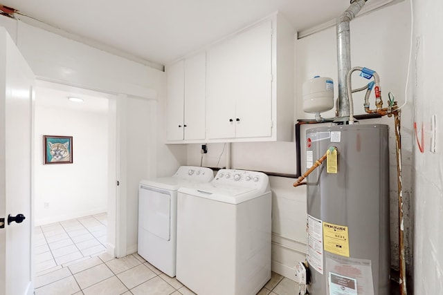 clothes washing area with separate washer and dryer, cabinets, light tile patterned floors, and water heater