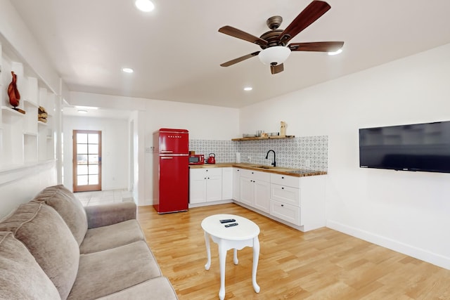 living room with sink, ceiling fan, and light hardwood / wood-style flooring