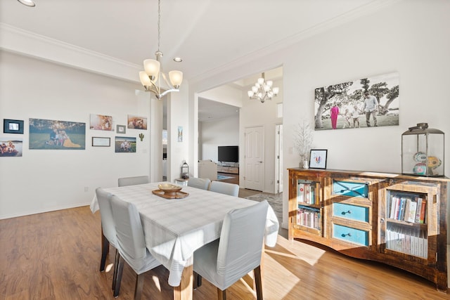 dining area featuring hardwood / wood-style floors, ornamental molding, and a chandelier