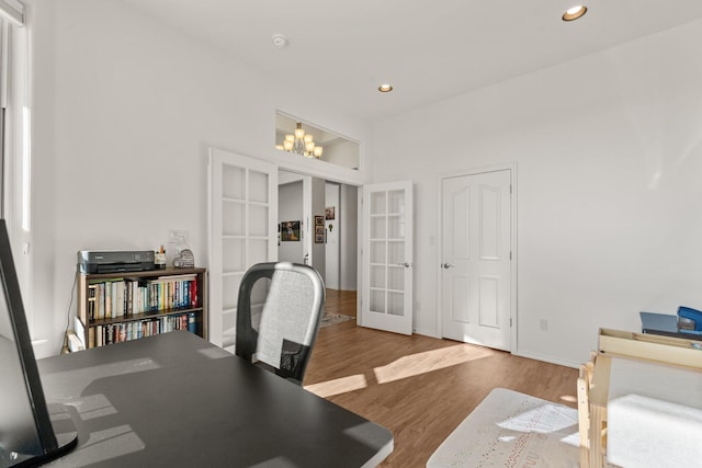 home office with french doors, wood-type flooring, and an inviting chandelier