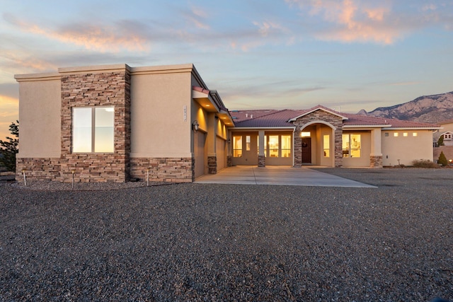 view of front facade with a mountain view and a patio area