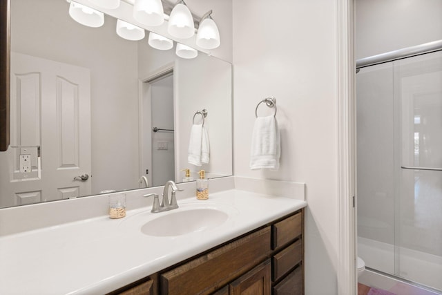 bathroom with vanity, toilet, and a shower with shower door