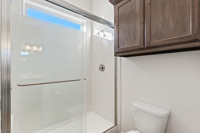 bathroom with toilet and a shower with shower door