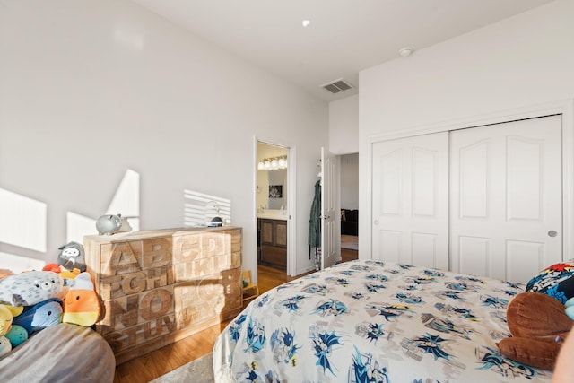 bedroom featuring hardwood / wood-style flooring, ensuite bathroom, and a closet