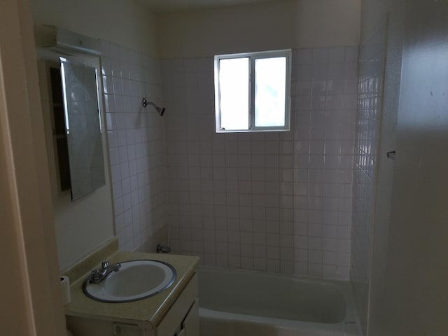 bathroom featuring vanity and tiled shower / bath combo