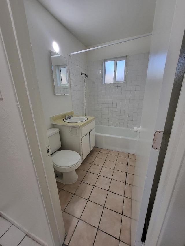 full bathroom with tile patterned flooring, vanity, tiled shower / bath combo, and toilet