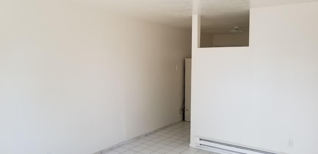 unfurnished room with a baseboard radiator and light tile patterned floors