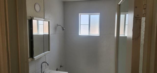 bathroom with a shower with door and sink