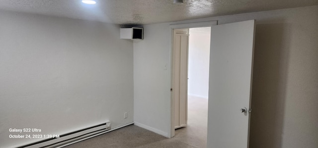 unfurnished room with a baseboard radiator and a textured ceiling