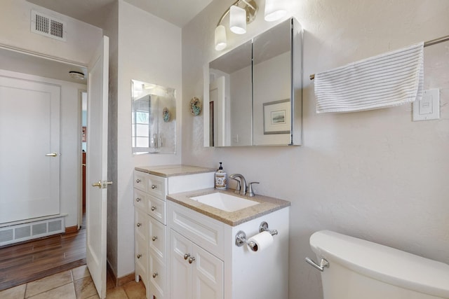 bathroom featuring vanity, toilet, and tile patterned flooring