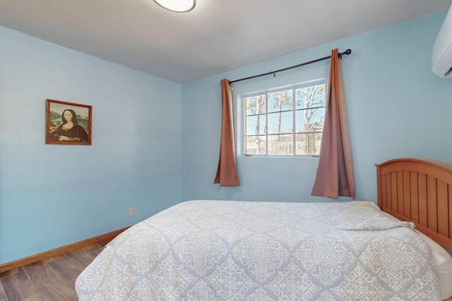 bedroom featuring hardwood / wood-style flooring and a wall mounted air conditioner