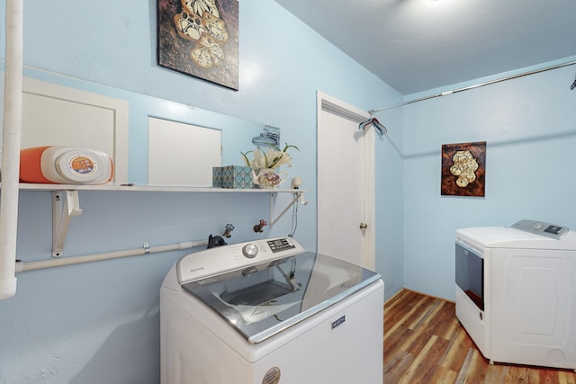 laundry area featuring hardwood / wood-style flooring and separate washer and dryer