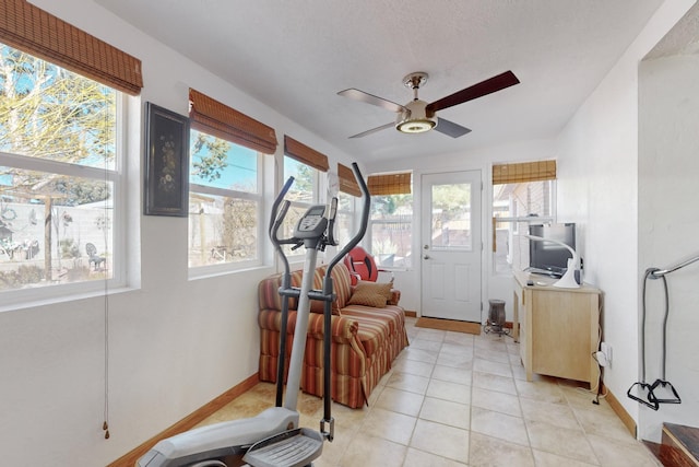 exercise room featuring light tile patterned floors and ceiling fan