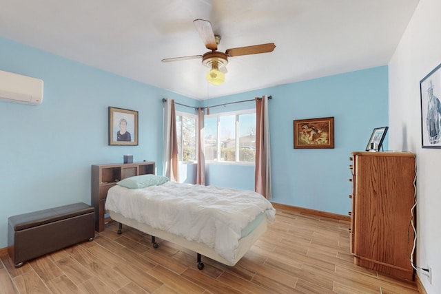 bedroom featuring ceiling fan, light hardwood / wood-style floors, and an AC wall unit