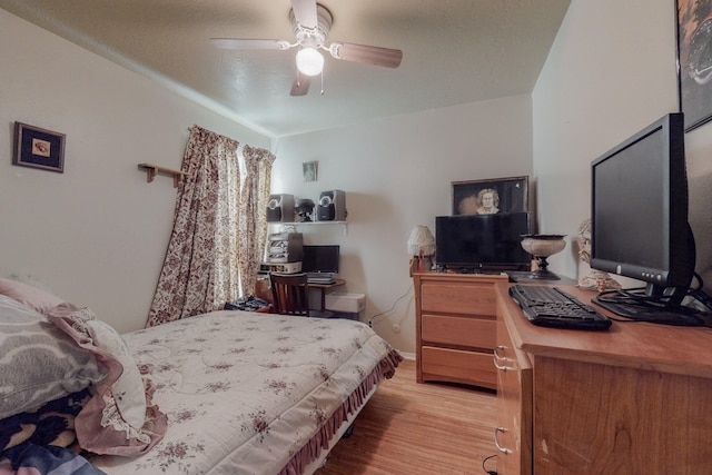 bedroom with ceiling fan, light hardwood / wood-style flooring, and a textured ceiling